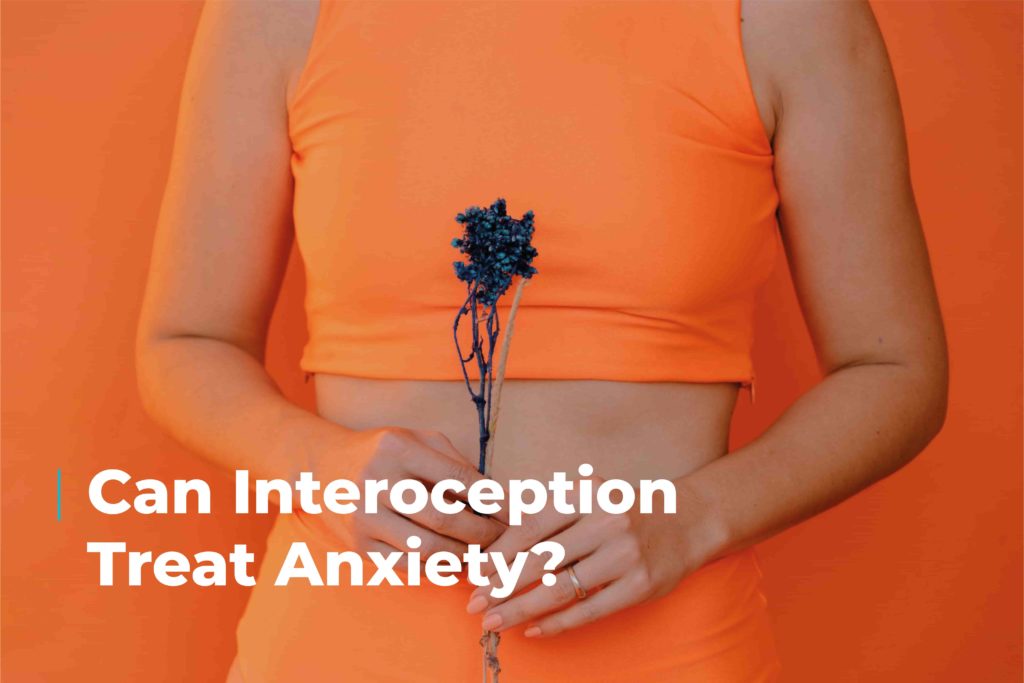 torso of woman in orange clothing holding a plant. Image includes caption "Can interoception treat anxiety?"