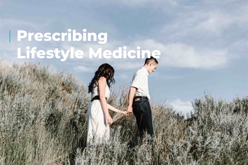 A couple holding hands stroll through tall vegetation, underneath a blue cloudy sky. Image includes the caption "prescribing lifestyle medicine"
